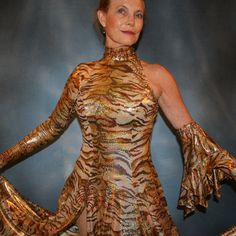 will fit size 5/6-9/10...5'6" or taller Be the envy of the dance floor with this stunning Gold Hologram Tango-Paso Doble Dress! Crafted of golden iridescent hologram tiger print lycra, this elegant ensemble boasts lots of flounces, a long sleeve with a peak at the wrist, and shimmering accents courtesy of volcano colored Swarovski rhinestones, which shine several different shades including purple & yellow. Make a statement with two thigh-high slits in the front, and show off your amazing tango Gold Fitted Disco Dress, Gold Fitted Dance Dress, Gold Fitted Dress For Dance, Hologram Printing, Spanish Princess, Spanish Dress, Tango Dress, Tiger Print, The Dance