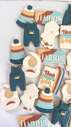 decorated cookies are arranged in the shape of baby's feet and clothes with words on them