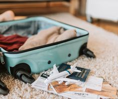 an open suitcase sitting on top of a carpet next to luggage tags and other items