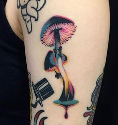 a woman's arm with tattoos on it, including an image of a mushroom