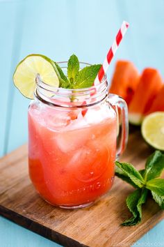 a watermelon and limeade drink in a mason jar on a cutting board