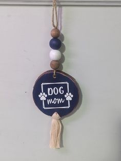 a dog mom sign hanging on the wall next to a tasseled bead