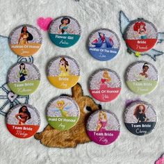 there are many disney princess buttons on the bed with their names and pictures in them