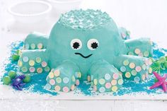 an octopus cake is decorated with blue icing and sprinkles on it