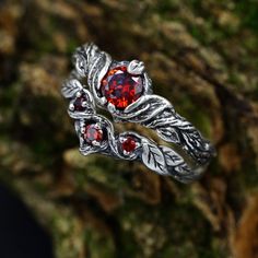 Crafted from sterling silver, this set features a nature-inspired design that encapsulates the spirit of the forest. The dainty silver leaves and unique garnet stones make this set a perfect choice for a woman who appreciates the delicate beauty of the natural world.  Characteristics: Metal - Recycled solid sterling silver  Stone - Cubic Zirconia Finish - Oxidized. View all silver nature wedding ring sets: https://www.etsy.com/shop/TinyShinyJewel?ref=seller-platform-mcnav&section_id=45348609 Care instructions: To care for the ring, avoid contact with water and chemicals such as perfumes and lotions. When the ring is not in use, store it in a dry, cool place to prevent tarnishing. Additional information:  ✦ All rings are made to order. An average turnaround time is 1-5 days. I will make eve Elegant Silver Jewelry For Fantasy Events, Silver Ethereal Jewelry With Birthstone, Ethereal Style Wedding Ring Jewelry, Silver Magical Promise Jewelry, Ethereal Sterling Silver Wedding Jewelry, Ethereal Sterling Silver Wedding Rings, Silver Nature-inspired Wedding Jewelry, Nature-inspired Silver Wedding Jewelry, Ethereal Silver Jewelry For Anniversary