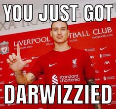 a man standing in front of a red wall with the words you just got darwized