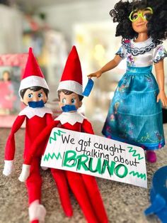 two elfs are holding a sign that says we got caught talking about bruno