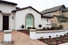 a white house with green shutters and landscaping