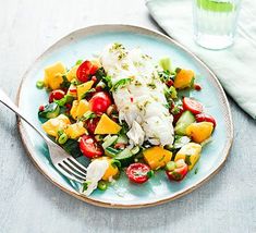 a blue plate topped with fish and veggies