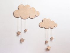 two wooden clouds and stars hanging from strings