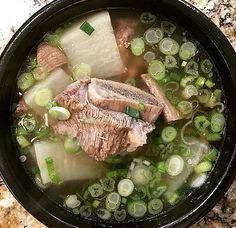 a bowl filled with meat and vegetables on top of a table