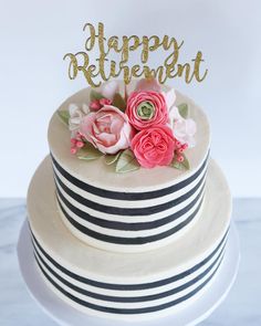 a white cake with pink flowers on top and the words happy retirement written in gold