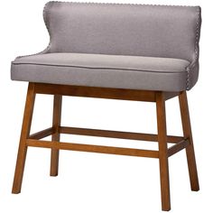 a gray upholstered chair with wooden legs and nail polishing on the armrests