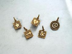 Crafted with precision and artistry, these brass embossed dainty charms-pendants are a perfect element for a jewelry collection. Choose from an assortment of captivating symbols as a heart, an arrow, a star, a pound sign or an ampersand tag. These are versatile charms, blending seamlessly with a casual or whimsy jewelry design, adding a unique flair and personalization to your creations. Elevate the look of your designs with these enchanting brass charms that effortlessly combines intricate deta Handmade Brass Charms For Jewelry Making, Antique Gold Brass Pendant Charm Necklaces, Antique Gold Brass Pendant Charm Necklace, Symbolic Yellow Gold Brass Charms, Nickel-free Brass Pendant Charm, Brass Pendant Charms With Dangling Details, Bronze Charm Necklace In Brass, Bronze Brass Charm Necklaces, Bronze Brass Charm Necklace