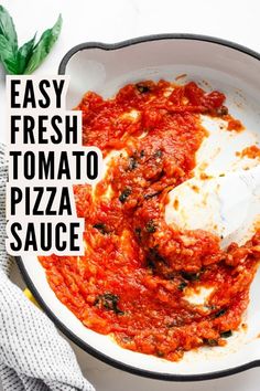 easy fresh tomato pizza sauce in a skillet on a white table with basil leaves