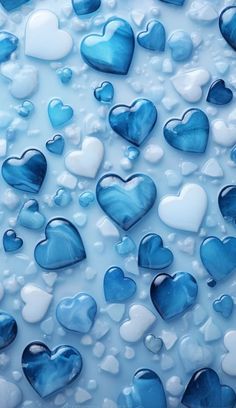 blue and white hearts are floating in the water with bubbles on it's surface