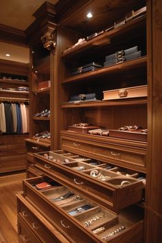 a large wooden closet with lots of drawers and shelves filled with necklaces, bracelets and other jewelry