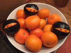 a white bowl filled with oranges on top of a wooden table