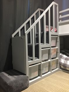 a white bunk bed with drawers underneath it and a gray towel on the bottom shelf