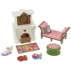 a doll house with furniture and accessories including a bed, chair, fireplace and rug