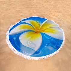 a round beach towel with a flower painted on it