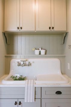 a white kitchen sink sitting under a cabinet