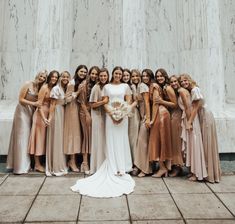 a group of women standing next to each other in front of a white marble wall