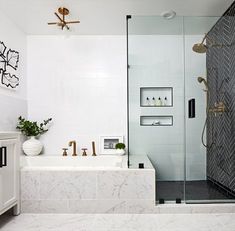 a bathroom with marble counter tops and white walls, along with a walk in shower