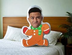 a cardboard cut out of a man with a christmas sweater on, sitting on a bed