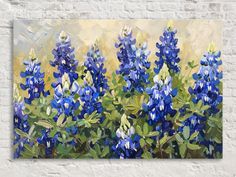 a painting of blue flowers on a white brick wall