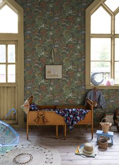 a room with wooden floors and wallpaper that has an animal theme on the walls