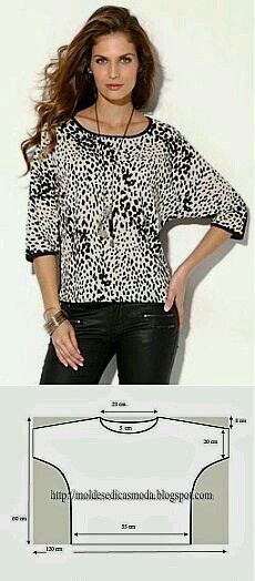 a woman standing in front of a white wall wearing black leather pants and a leopard print top