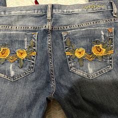 Guess Jeans, Low Rise, Flare Leg, Embroidered With Yellow And Orange Sunflower Type Things On The Front Pockets And The Back Pockets. Yellow Bottoms With Floral Embroidery For Summer, Yellow Floral Embroidered Bottoms For Summer, Yellow Floral Embroidery Bottoms For Summer, Yellow Floral Embroidery Bottoms For Spring, Spring Yellow Bottoms With Floral Embroidery, Yellow Embroidered Bottoms For Summer, Embroidered Yellow Cotton Bottoms, Yellow Embroidered Summer Bottoms, Yellow Embroidered Cotton Bottoms