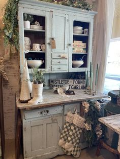 an old fashioned china cabinet is decorated with christmas stockings and stocking hanging from it