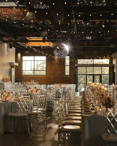 a room filled with lots of white tables and chairs