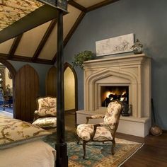 a bedroom with a bed, chair and fireplace in it