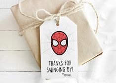 a gift wrapped in brown paper with a spider - man tag attached to it and the words thanks for swinging by