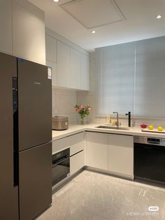 a modern kitchen with stainless steel appliances and white counter tops, along with marble flooring