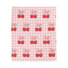 a pink and white checkered table cloth with cherries on it