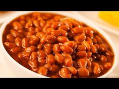 a white bowl filled with baked beans on top of a table