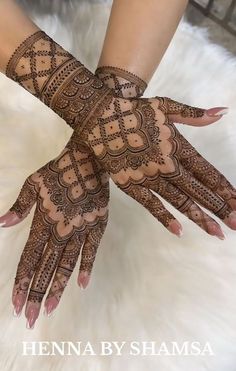 henna by shamsa on her hands with intricate designs in the middle and bottom