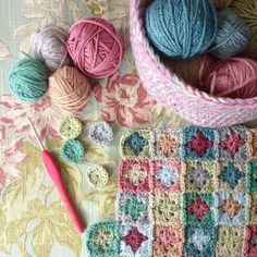 yarn and crochet items laid out on top of a table with pink scissors