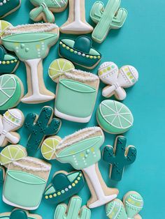 decorated cookies arranged in the shape of cocktails and margarita glasses on a blue background