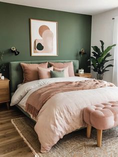 a bedroom with green walls, pink bedding and an art piece on the wall