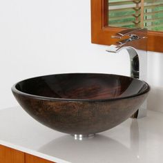 a black bowl sink sitting on top of a white counter