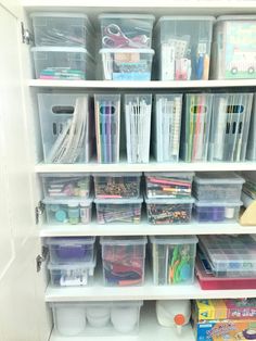 an organized closet with plastic bins and craft supplies on the bottom shelf in front of it