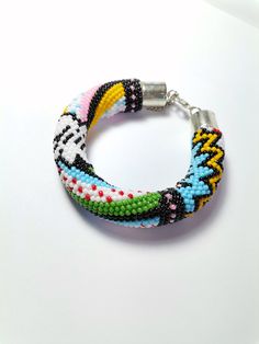 Feel the Boom 💣 with this colorful crocheted bracelet.  This item is so versatile it can make each and every outfit pop. Multicolor Braided Bead Bangle Bracelet, Multicolor Braided Bracelet Bangle, Multicolor Braided Bangle Bracelet, Casual Multicolor Braided Bracelets With Colorful Beads, Multicolor Braided Bracelet With Round Beads, Multicolor Beaded Braided Bracelets, Casual Multicolor Braided Bracelets With Round Beads, Multicolor Braided Jubilee Friendship Bracelets, Bohemian Adjustable Beaded Crochet Bracelets