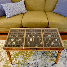 a coffee table with shells on it in front of a couch