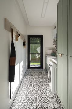 a white and black tiled floor in a kitchen next to a washer and dryer