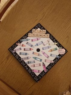 a wooden table topped with a white and black square shaped sign that says music thomas